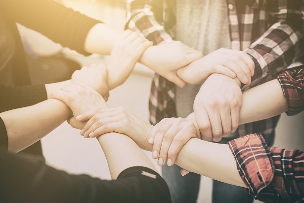 Individuals holding hands as a team