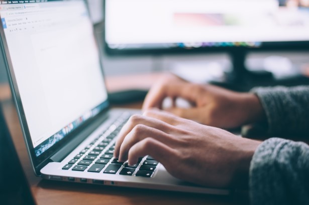 Photo of someone writing on a laptop