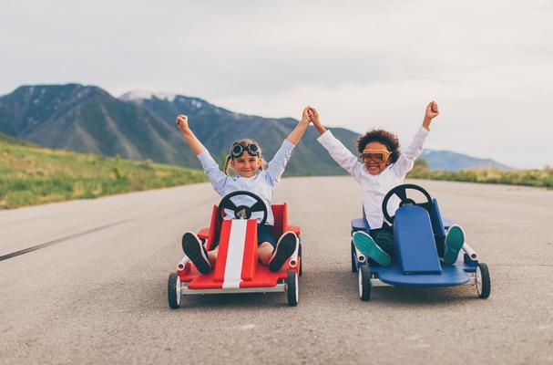 Go karters with arms raised in celebration