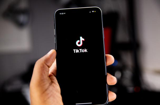 Hand holding a phone and viewing TikTok