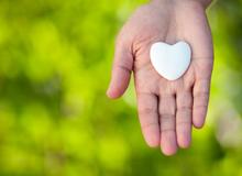 Heart pebble in hand