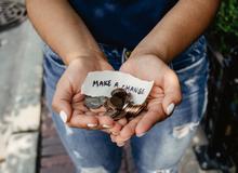 Open hands with coins for fundraising