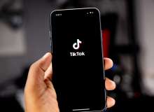 Hand holding a phone and viewing TikTok